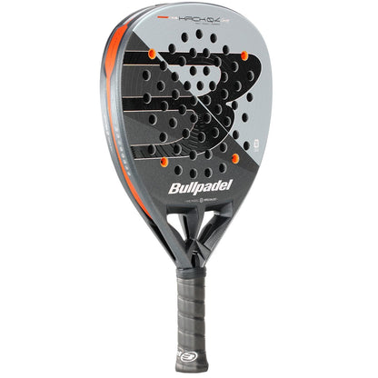 The Bullpadel HACK 04 Comfort 2026 Padel Racket in grey and black features an orange accent, round head shape, dynamic power, multiple circular holes, and a black grip handle.