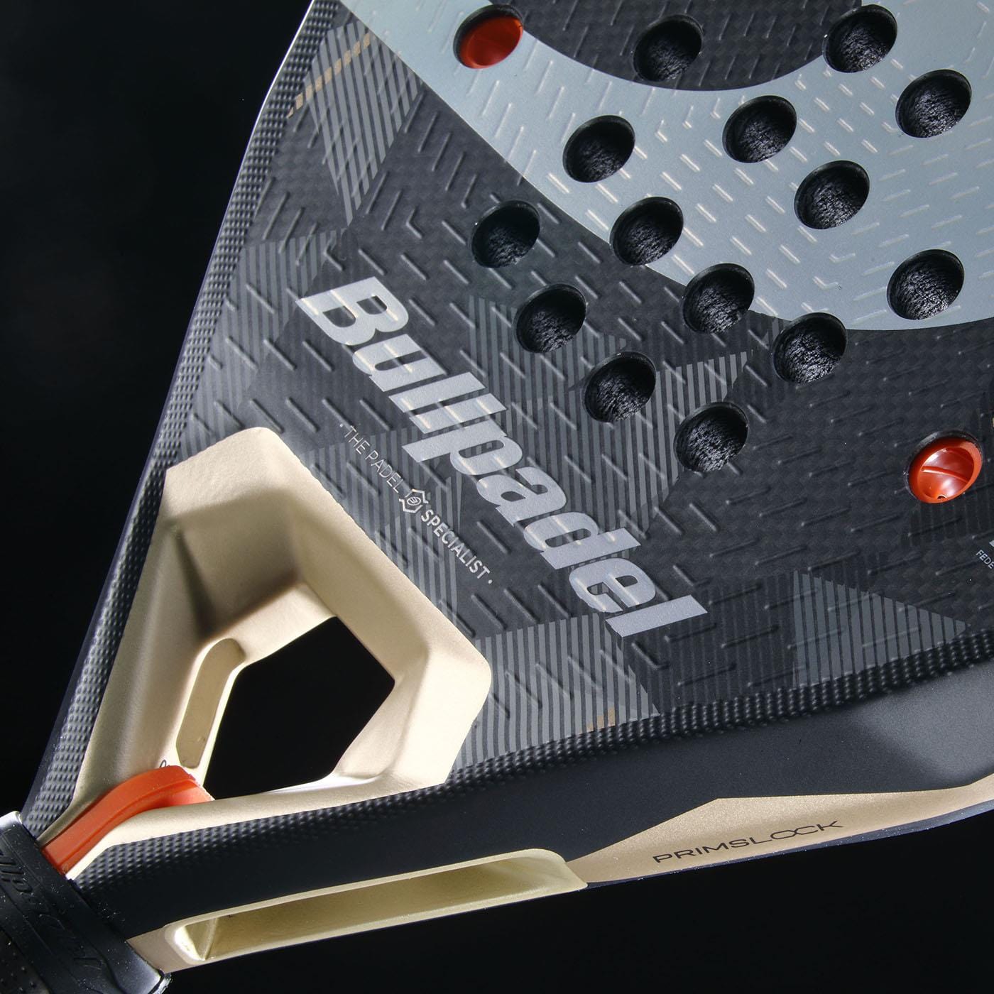 Close-up of the Bullpadel Neuron 02 2026 Padel Racket in Black/Gold, showcasing its textured surface, circular holes, visible Bullpadel logo, and orange-accented handle—designed for professional padel players.