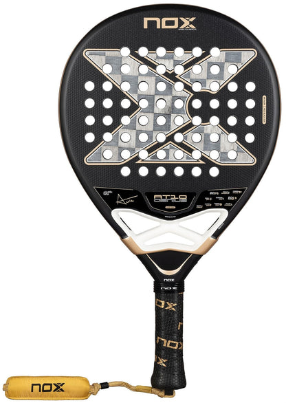The NOX AT10 Genius 18K Alum By Agustín Tapia 2026 Padel Racket features a black design with gold and white accents, large X detail, circular holes, Dual Spin surface for control, plus a black handle with gold NOX logo and yellow wrist strap.