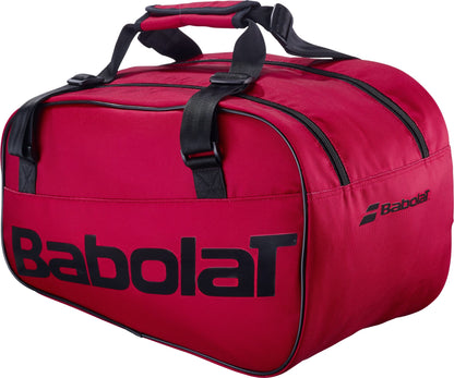 The Babolat Court S Padel Racket Bag - Burgundy features black handles, black zippers, and a black Babolat logo text on the side. This stylish bag offers two main compartments and a padded handle grip, making it an ideal choice for carrying all your essential padel equipment.