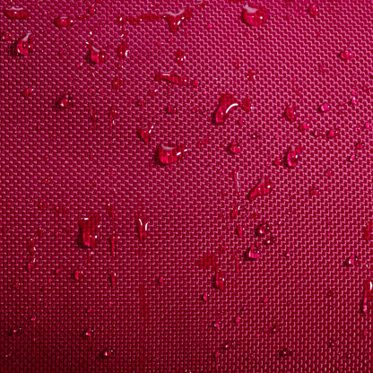 Close-up of water droplets resting on a textured, deep burgundy fabric surface, similar to the durable material featured on the Babolat Court S Padel Racket Bag by Babolat. The grid-like pattern beneath the droplets highlights the exceptional craftsmanship and quality typical of premium padel gear.