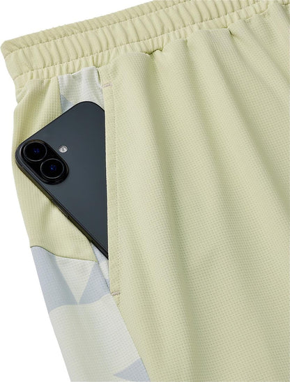 A black smartphone peeks out from the pocket of Yonex 15240YX Knit Mens Padel Shorts in Champagne, featuring a breathable knit fabric and elastic waistband.
