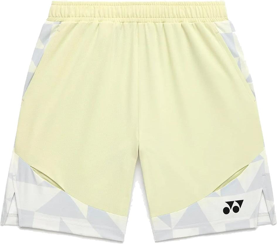 The Yonex 15240YX Knit Men's Padel Shorts in Champagne feature light yellow breathable fabric, an elastic waistband, side pockets, geometric white and gray lower patterns, and a black logo on the right leg—perfect for padel.