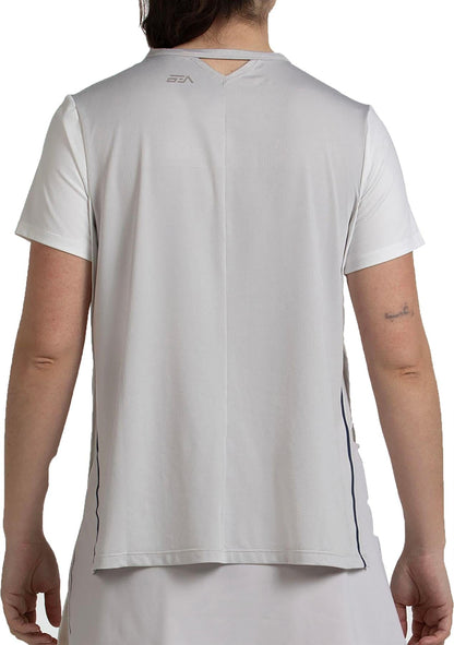 A woman is shown from the back wearing a Bullpadel Picase Women’s Padel T-Shirt in Bone, featuring short sleeves, moisture-wicking fabric, a small Bullpadel logo near the neck, and a keyhole detail below the collar.