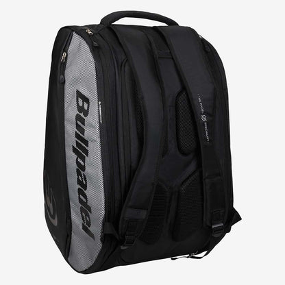 The Bullpadel BPP26001 Vertex Padel Racket Bag in black, with padded straps and multiple zippered compartments, is ideal for carrying padel gear. The bag stands upright on a plain white background.