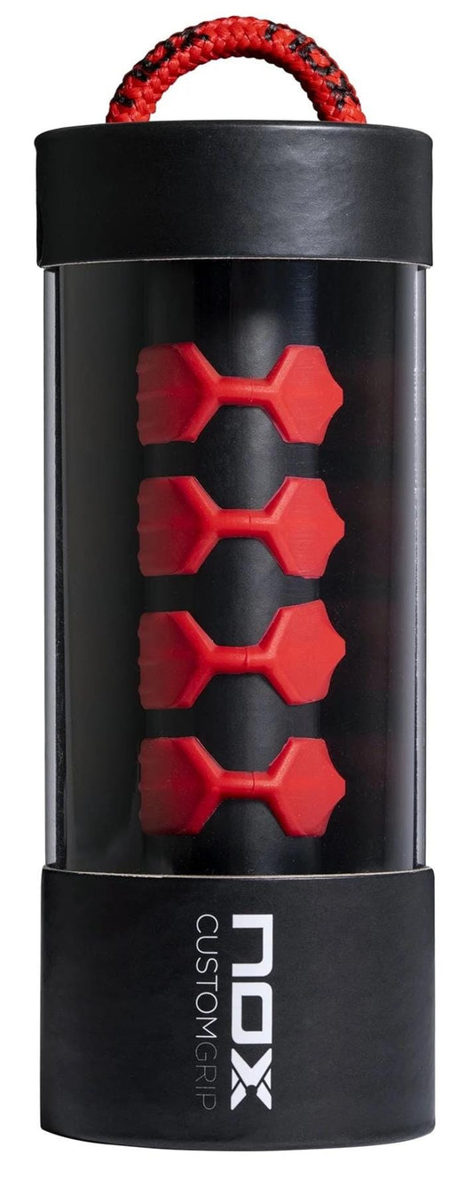 The Nox Padel Custom Grip - Red by NOX comes in a cylindrical package with a clear window showing five red silicone rings. The black box features a red and black rope handle and “NOX Custom Grip” text, designed to reduce vibrations for comfort.
