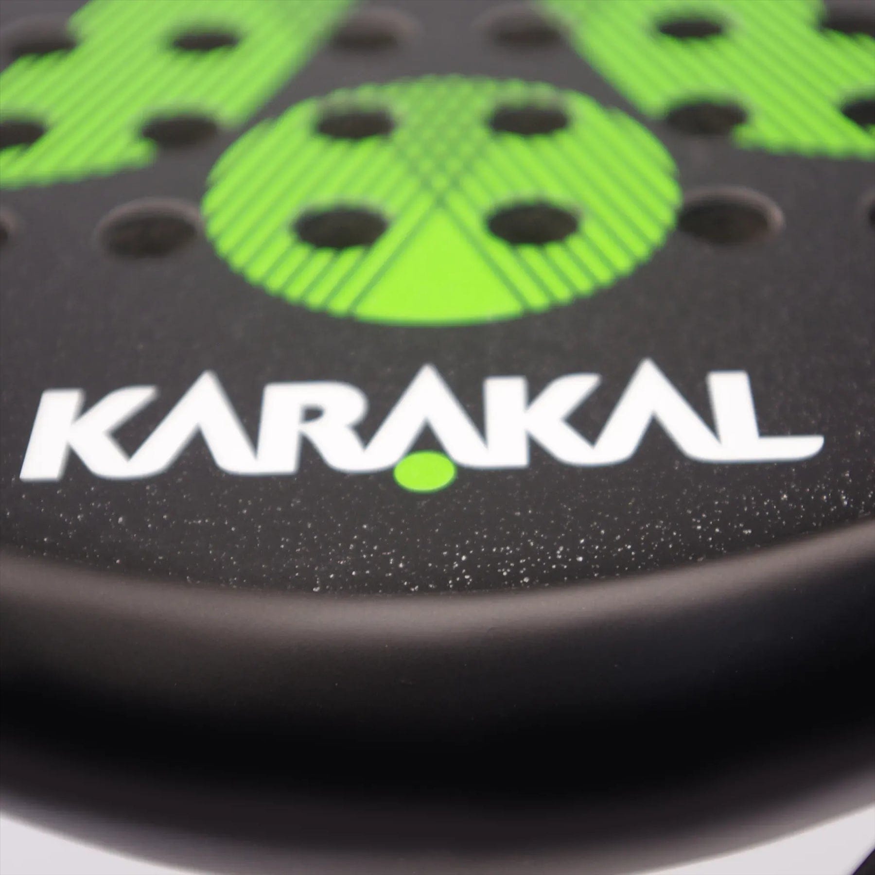 Close-up of the Karakal Air Lite 345 Green Padel Racket featuring green circular patterns, holes, and bold white "KARAKAL" lettering with a green dot, highlighting its lightweight design.