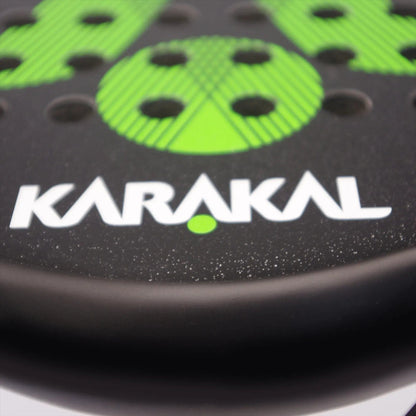 Close-up of the Karakal Air Lite 345 Green Padel Racket featuring green circular patterns, holes, and bold white "KARAKAL" lettering with a green dot, highlighting its lightweight design.