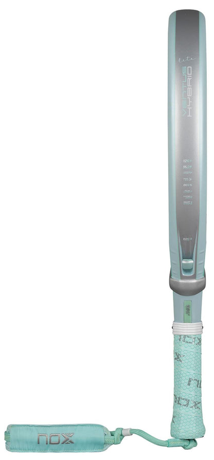 The NOX Luxury Ventus 12K Hybrid Lite 2026 Padel Racket in blue features "NOX" branding, a padded wrist strap, and a textured handle crafted from 12K carbon fibre for enhanced grip and performance.