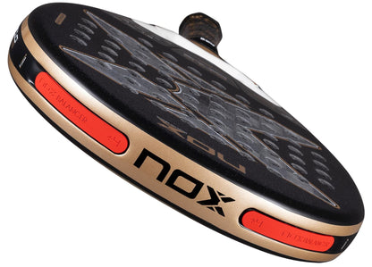 Close-up of the NOX AT10 Genius 18K Alum By Agustín Tapia 2026 Padel Racket in black and gold, highlighting its Dual Spin surface, NOX logo, and red adjustable NOX Weight Balance system on the edge.