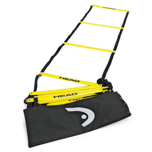 A yellow HEAD Agility Ladder spans a white surface next to a black carrying bag. Ideal for improving footwork and fitness, this vital training tool is perfect for drills in various sports.