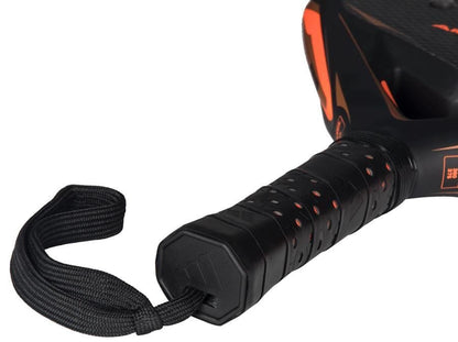 Close-up of the adidas Arrow Hit CTRL 2026 Padel Racket handle in black and orange, showing a black wrist strap, textured grip, perforations, and an intelligent balance system for enhanced control.