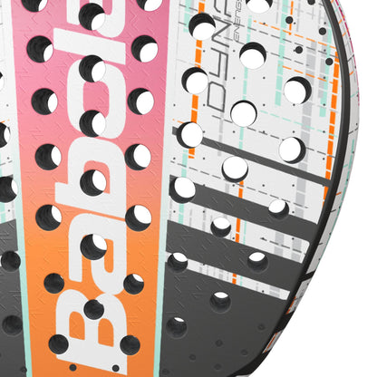 Close-up of the Babolat Dyna Energy Padel Racket, showcasing its colorful geometric design in white, black, orange, and pink. This paddle features Carbon Flex technology and includes multiple circular holes, with the brand name "Babolat" partially visible in white text.