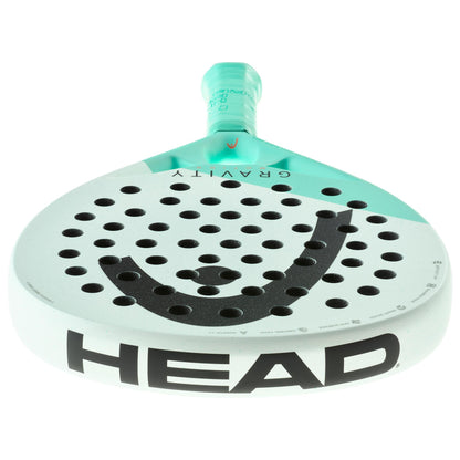 A mint-colored paddle racket from HEAD, showcasing its Gravity Motion design with Spin Surface technology. It features a perforated surface and prominently displays the brand name "HEAD" in bold black letters on the side, along with a stylized "H" logo at the top.