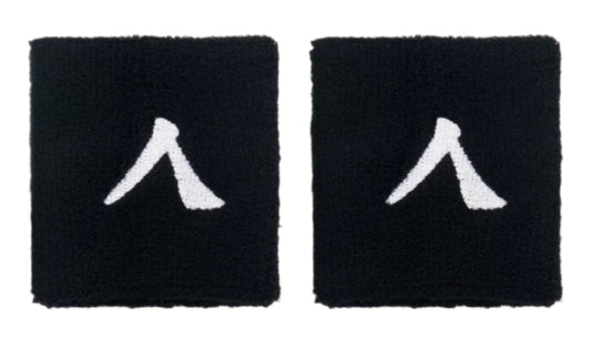 The Kanso 7cm Wristband, made from absorbent fabric for optimal comfort, features two black wristbands with a white stylized logo, displayed side by side on a light gray background.