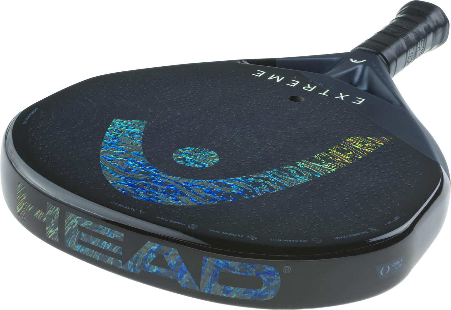 A close-up of the HEAD Extreme One X 2025 Padel Racket in Black/Blue shows its shiny holographic branding, 12K Carbon Fibre textured face, and grip handle.