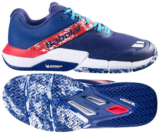 The Babolat Movea 2 Men's Padel Shoes in dark blue with chilli red and white accents feature turquoise laces, durable Michelin rubber soles with textured tread, and display the Michelin logo.