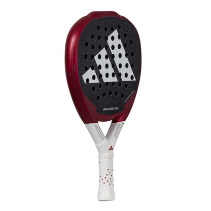 The ADIDAS Metalbone Team 3.3 Padel Racket - Red by adidas features a striking red and black design with a distinctive white logo. Its face is perforated, and the unique diamond-shaped head is crafted to enhance performance. The racket includes a white handle with red accents and incorporates Spin Blade Grit technology, offering superior control and spin for padel sports.