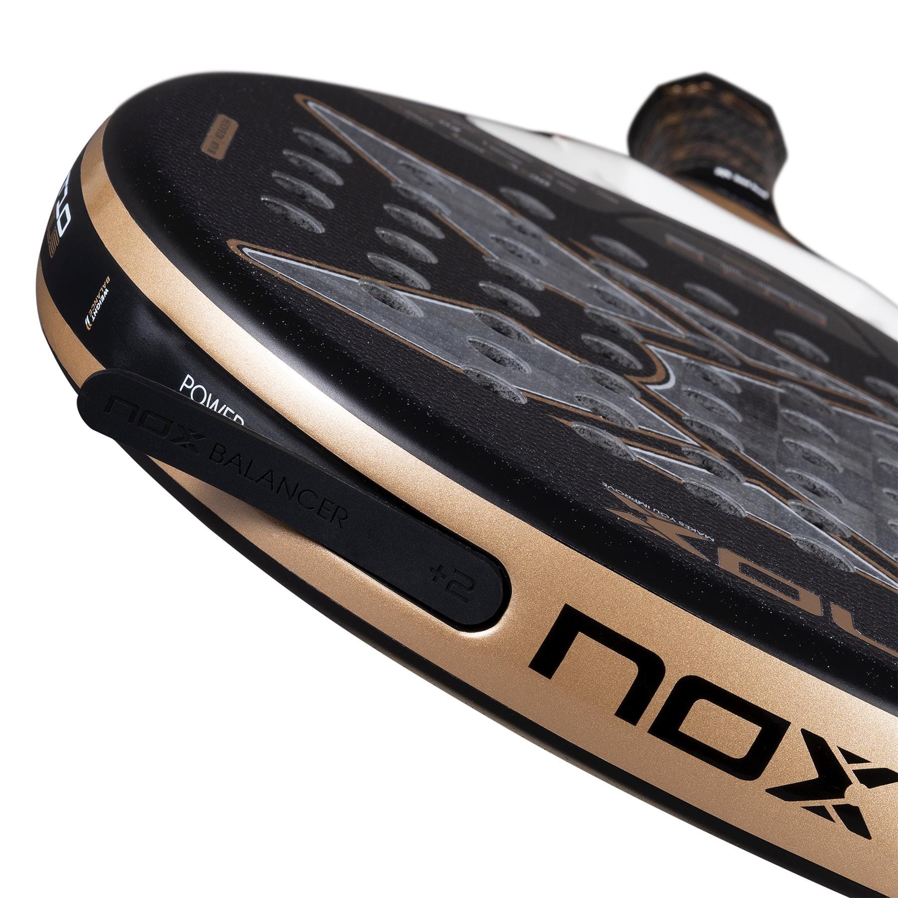 Close-up of the NOX AT10 Genius 18K Alum By Agustín Tapia 2026 Padel Racket in black and gold, with a perforated Dual Spin surface, “NOX BALANCER +2” on the edge, and a textured grip handle.