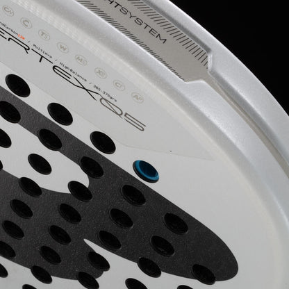 Close-up of the Bullpadel Pearl 2026 Padel Racket - White, a lightweight racket with perforated surface, blue hole, and branding along the edge. Its design stands out against a black background and aims to help prevent injury.