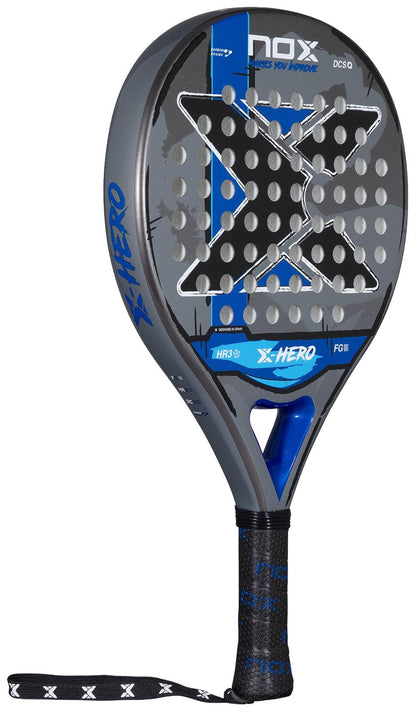 The NOX X-Hero Blue Padel Racket features black, blue, and gray colors with circular holes, a large “X” design, black grip, and white accents. This NOX racket ensures control and precision—an ideal choice for padel beginners.