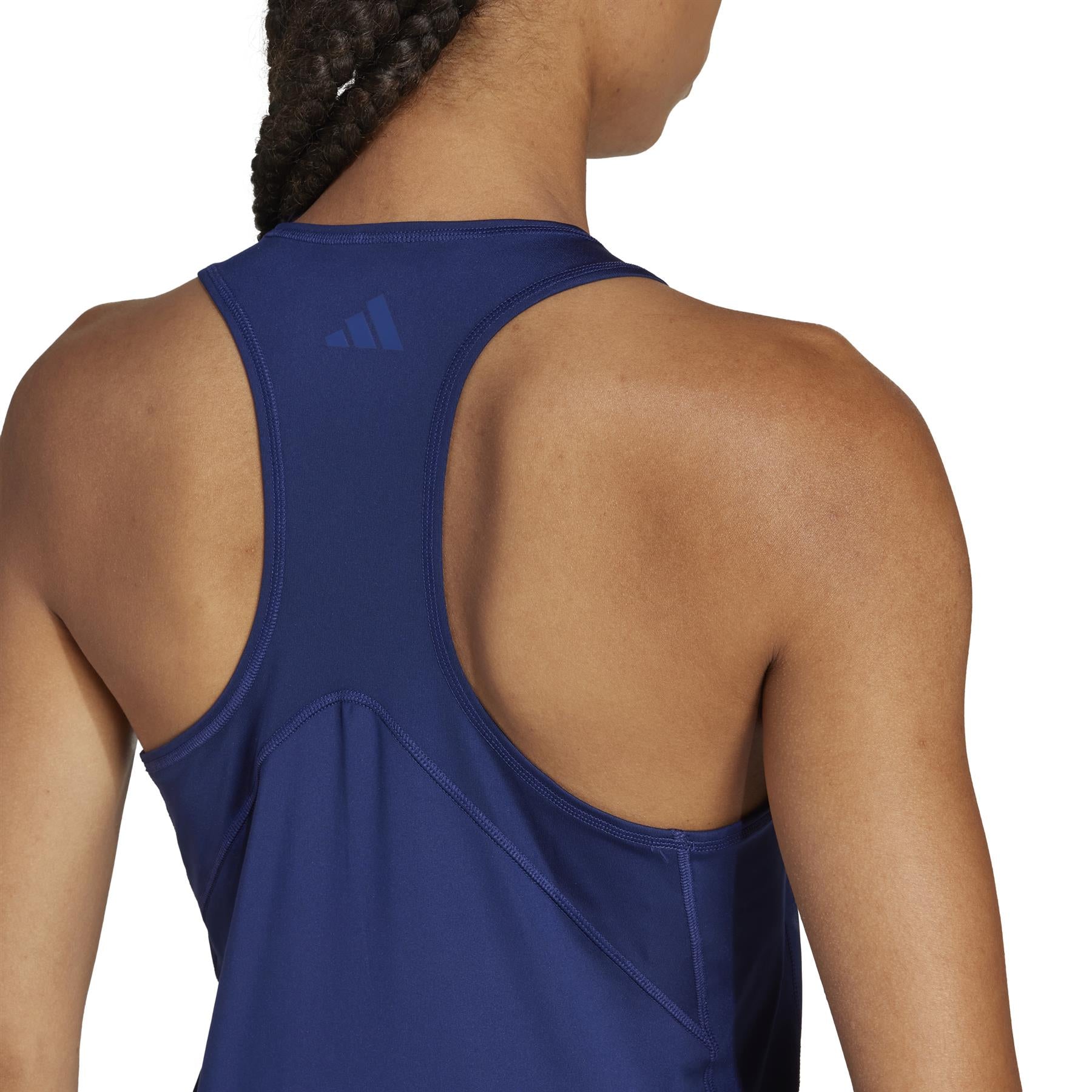 Rear view of a person in the adidas Women's Club Padel Tank Top - Navy, made from recycled materials with a racerback design. A small logo near the neckline adorns the back, and braids add flair. Climacool technology ensures they remain cool and comfortable.