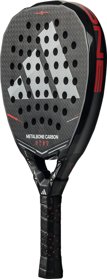 The adidas Metalbone Carbon 2026 padel racket features a black and red design, perforated face, gray adidas logo, and "METALBONE CARBON" text on the front. Ideal for advanced players, it has a black grip with red accents for top performance.