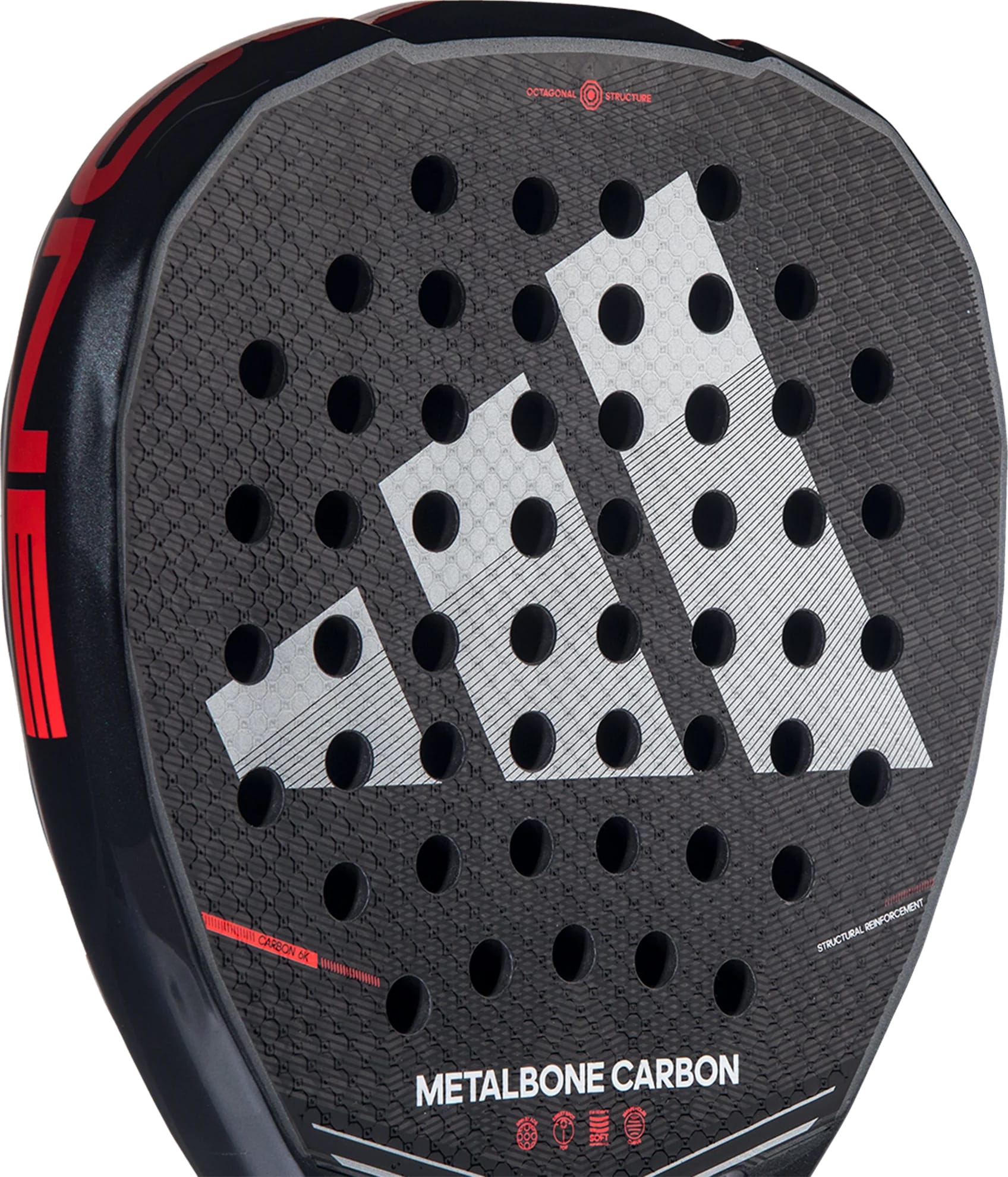 Close-up of the adidas Metalbone Carbon 2026 padel racket, showing a honeycomb pattern, bold white geometric logo, circular holes, red accents, and "METALBONE CARBON" text—ideal for advanced players who value precision.