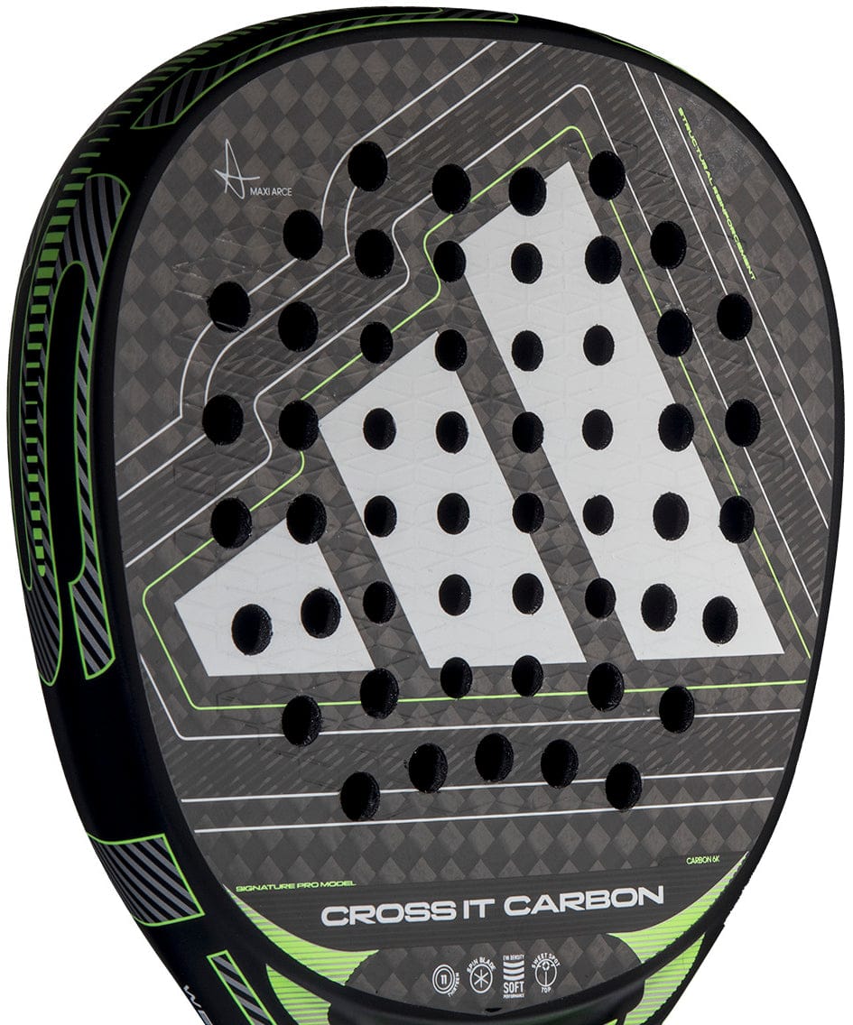 Close-up of the adidas Cross It Carbon 2026 Padel Racket - Black / Green, an advanced-level carbon fibre racket featuring a large white geometric logo, circular perforations, green accents, and "CROSS IT CARBON" at the bottom of the face.