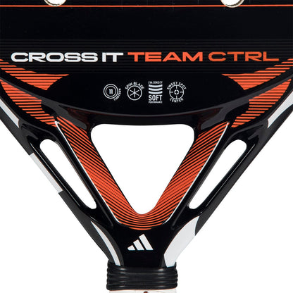 Close-up of the adidas Cross It Team Ctrl 2026 Padel Racket in black and orange, with "CROSS IT TEAM CTRL" text and icons for Spin Blade, Soft, Sweet Spot Center, and Extra Power Grip on its surface.