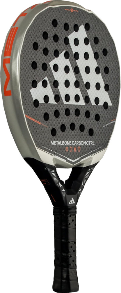 The adidas Metalbone Carbon CTRL 2026 padel racket is black and gray, built for advanced players, with a large white logo, round face holes, “Metalbone Carbon CTRL” by the handle, and a black grip tape-wrapped handle.