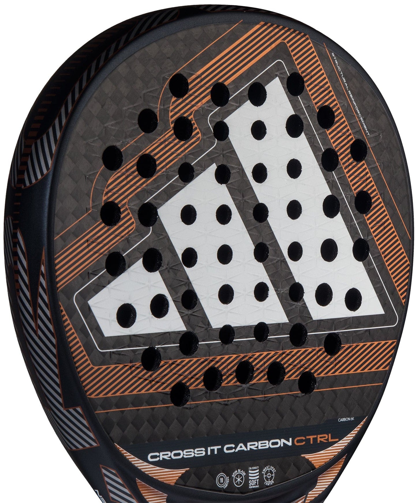 Close-up of the adidas Cross It Carbon Ctrl 2026 Padel Racket – Black, featuring a white geometric design with orange accents. This carbon fibre racket offers an Extra Power Grip and has multiple circular holes on its surface.