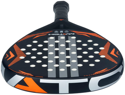 Close-up of the adidas Match Black 2026 Padel Racket - Black / Orange, a beginner racket with fibreglass construction, orange and white accents, round holes, and a textured handle facing away from the viewer.
