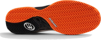 The image shows the orange herringbone outsole of Bullpadel Indiga 26I Mens Padel Shoes - Orange, featuring visible branding and a breathable mesh upper for performance.