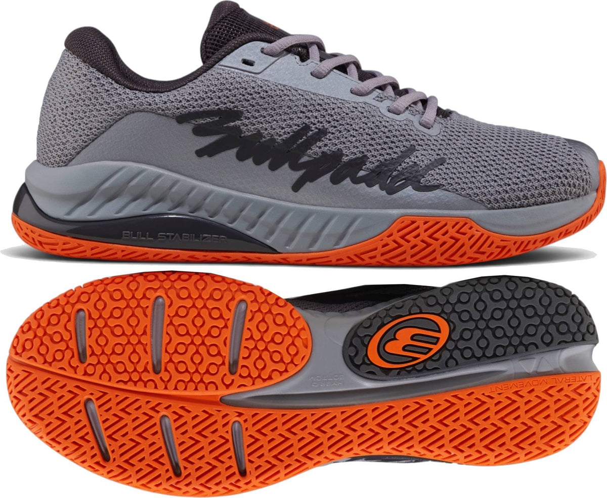 The Bullpadel Ionic 26I Mens Padel Shoes - Dark Grey, designed for intermediate and advanced players, feature a textured sole and “Bullpadel” in black script on the side, shown from the side and bottom.