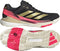 The adidas Crazyquick Boost Men’s Padel Shoes in Core Black/Gold Metallic/Solar Turbo feature black uppers with gold stripes, pink and beige accents, and a beige sole with bright pink sections for grip and energy return, shown side and bottom.