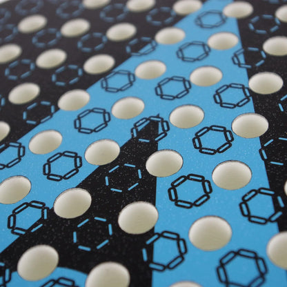 Close-up of the Karakal Chaos Dynamic 2026 Padel Racket, featuring a 12K carbon graphite surface with a pattern of circular holes over a black and blue graphic design.