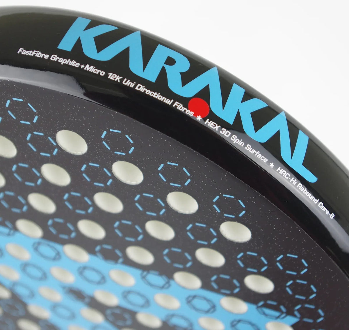 Close-up of a black Karakal Chaos Dynamic 2026 padel racket with a textured surface featuring a grid of circular holes and light blue hexagonal outlines.