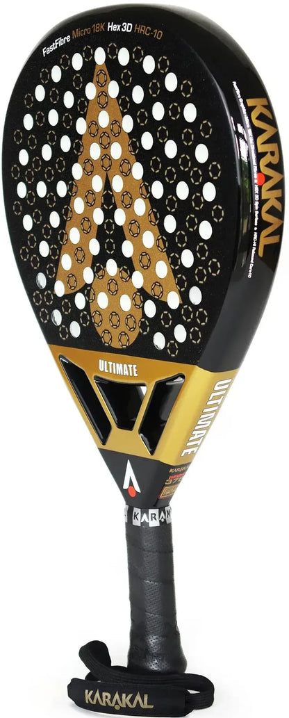 A black and gold Karakal Chaos Ultimate 2026 padel racket with a teardrop-shaped head, a perforated face, a triangular cutout in the bridge, and a black handle with a wrist strap.