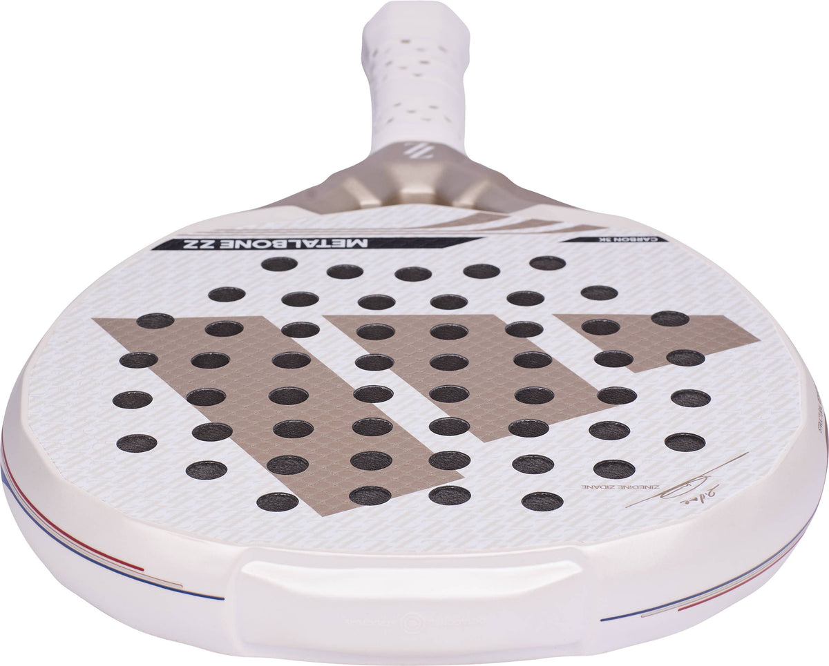 A white ADIDAS Metalbone ZZ Carbon Zinedine Zidane 2026 Padel Racket featuring a grid of circular holes, metallic accents, and a signature on the lower face.