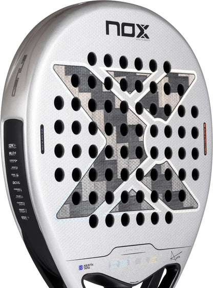 Silver and grey NOX AT10 Genius 12K Alum Xtrem By Agustín Tapia 2027 padel racket with a perforated surface, featuring a large black X pattern in the center and technical specification text printed along the side.