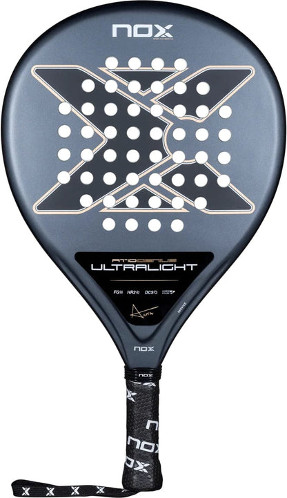 A teardrop-shaped NOX AT10 Genius Ultra Light By Agustín Tapia 2026 padel racket featuring a dark grey surface, a central X-pattern of holes, and a black handle with a wrist strap.