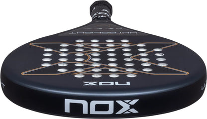 NOX AT10 Genius Ultra Light By Agustín Tapia 2026 padel racket in black, featuring a circular hole pattern, bronze graphic accents, and white logo text on the frame.