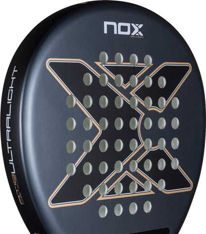 Black round NOX AT10 Genius Ultra Light By Agustín Tapia 2026 padel racket with a textured face featuring an X-shaped pattern and circular perforations.