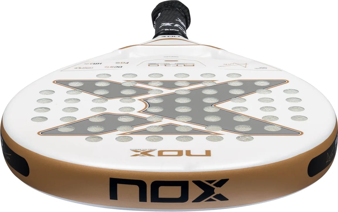 NOX AT10 Genius Junior 2026 padel racket in white and gold, featuring a centered dark grey X-shaped pattern with circular perforations.