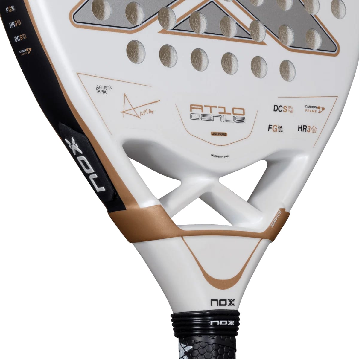 White NOX AT10 Genius Junior 2026 padel racket with a perforated face, copper-colored accents, and technical branding text.