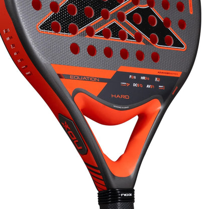 Close-up of a NOX Equation Hard Advanced 2027 padel racket featuring a black and orange perforated face with a V-shaped bridge and a black handle.