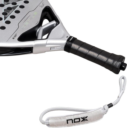 Silver NOX AT10 Genius Attack 12K Alum Xtrem By Agustín Tapia 2027 padel racket with a black perforated grip and a gray wrist strap featuring a logo.