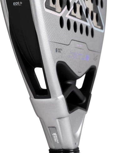 A silver and black NOX AT10 Genius Attack 12K Alum Xtrem By Agustín Tapia 2027 padel racket with a teardrop-shaped head, featuring open triangular throat cutouts and visible text branding on the frame.