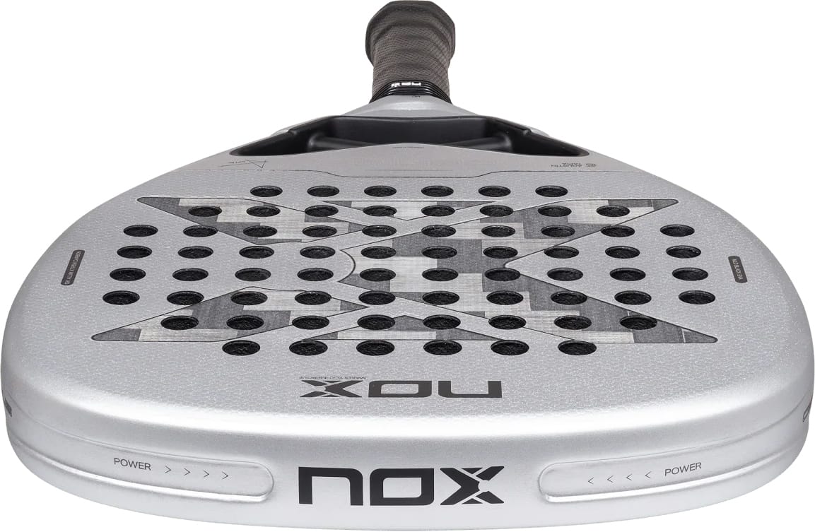 Silver NOX AT10 Genius Attack 12K Alum Xtrem By Agustín Tapia 2027 padel racket with a diamond-shaped head, a black grip, and a geometric pattern over the perforated face.